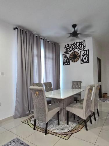 a dining room with a table and chairs at HOMESTAY KLeMERU E POH in Chemor