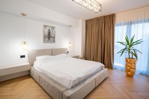 Un dormitorio con una cama grande y una ventana grande. en Lake view apartment - free parking, en Râmnicu Vâlcea