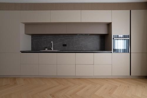 Una cocina con gabinetes blancos y un fregadero. en Lake view apartment - free parking, en Râmnicu Vâlcea