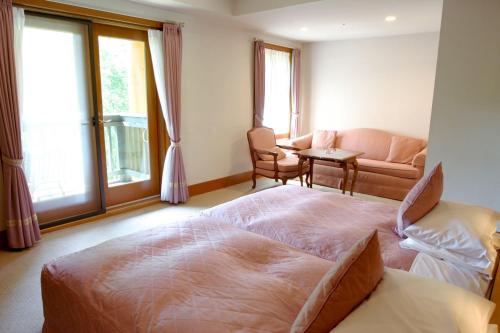 a bedroom with a large bed and a living room at Chuzenji Kanaya Hotel in Nikko