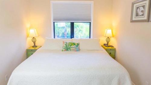 サニベルにあるSanibel Island retreat with private beachの2つのランプが付いた白いベッドのある寝室