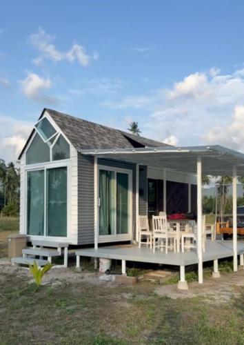 a small house with a porch and chairs at Beachfront Tiny House, Koh Samui, Thailand with FREE Rowboat in Amphoe Koh Samui