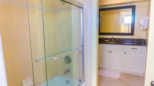 サニベルにあるRenovated 3-BR Villa with Rooftop Sundeck, Gulf Views and Private Beachのバスルーム(ガラス張りのシャワー、シンク付)