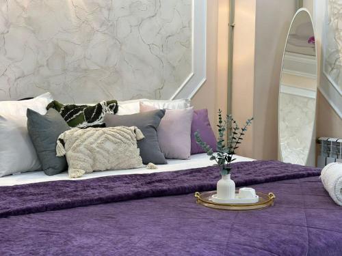 a purple and white bed with pillows on it at Уютный уголок in Shymkent