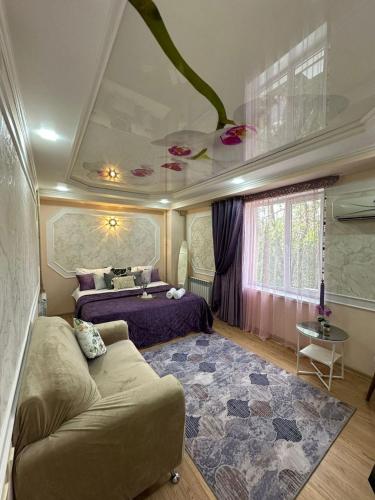 a bedroom with a bed and a couch in a room at Уютный уголок in Shymkent
