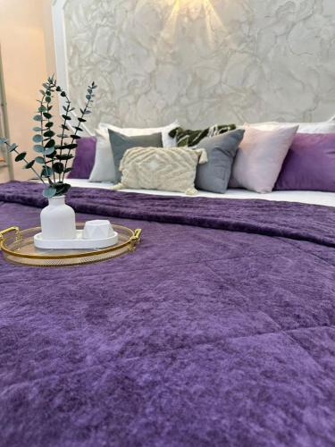 a large purple bed with a table on top of it at Уютный уголок in Shymkent