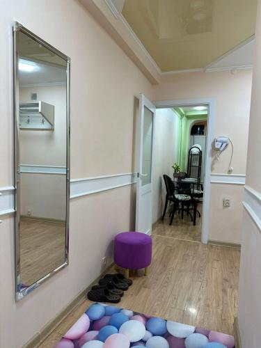 a room with a mirror and a purple stool at Уютный уголок in Shymkent