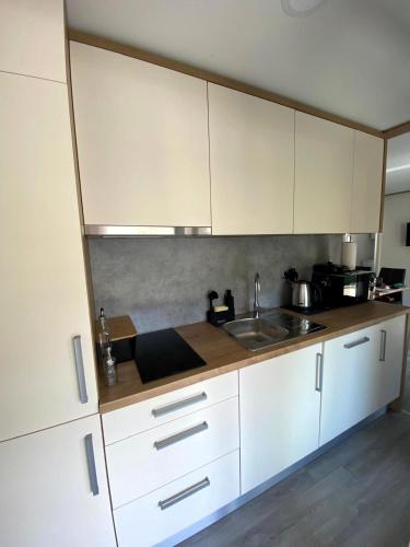 a kitchen with white cabinets and a sink at Mobilna kućica Neda - Grebaštica, kamp Vala in Grebaštica