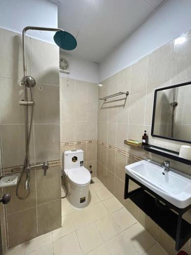 a bathroom with a shower and a toilet and a sink at Ruby Căn hộ Dịch vụ Khách sạn in Ga Phú Văn
