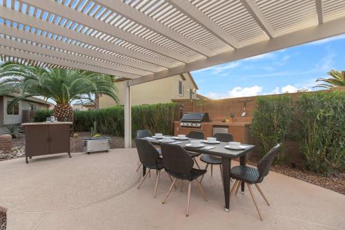 a patio with a table and chairs under a pergola at Monte Cristo Home - Epic Backyard Pool Spa & Firepit in Surprise