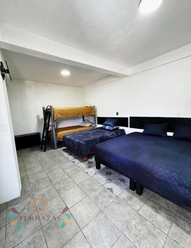 a bedroom with two beds in a room at Terrazas Hotel and Hostel in Taxco de Alarcón