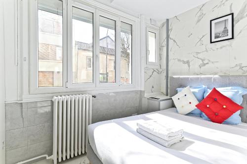 - une chambre blanche avec un grand lit et des fenêtres dans l'établissement Studio Les Lilas, aux Lilas