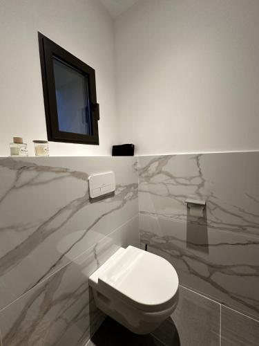 a bathroom with a toilet and a tv on a wall at les gites de la Fée in Cavaillon