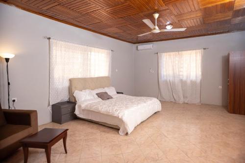 a bedroom with a bed and a ceiling fan at The Everette Lodge in Sekondi-Takoradi