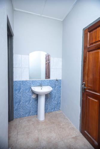 a bathroom with a sink and a mirror at The Everette Lodge in Sekondi-Takoradi