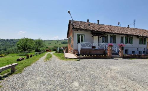 a small house on a gravel road next to a field at La Letizia in Cocconato