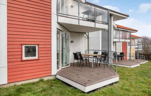 a deck with a table and chairs on a house at Gudhjem Søpark Lejl 19 in Gudhjem