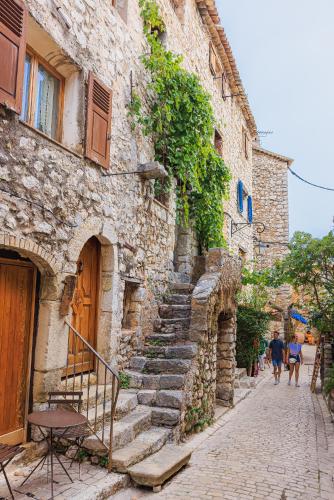 une allée en pierre avec des escaliers menant à un bâtiment dans l'établissement Maison Liberation - Centre Tourrettes sur Loup, à Tourrettes-sur-Loup