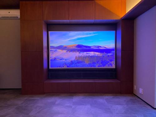 a large screen television on a wall in a room at The Park Villa in Ichinomiya