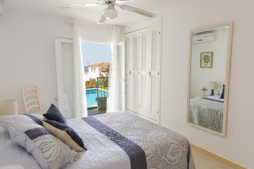 une chambre blanche avec un lit et une fenêtre dans l'établissement Villa Zodiaco Aries, à Son Bou