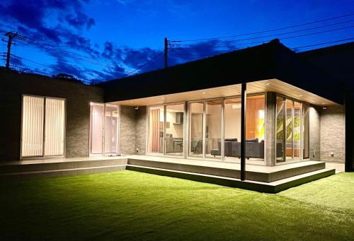 a house with a green lawn in front of it at The Park Villa in Ichinomiya