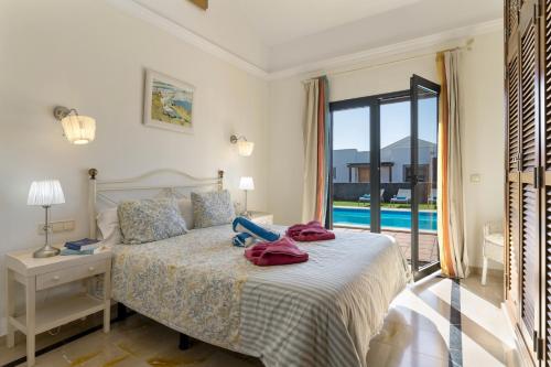 a bedroom with a bed and a view of a pool at Villa Ambar Cherry in Playa Blanca
