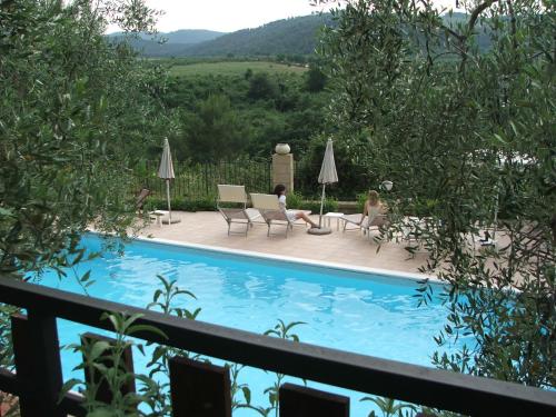 a swimming pool with two people sitting in chairs next to it at Agriturismo Fara del Falco in Vieste