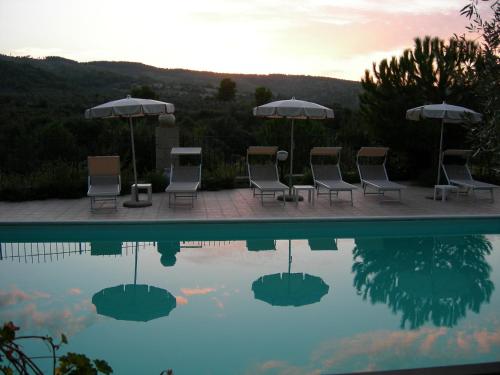 a group of chairs and umbrellas next to a pool at Agriturismo Fara del Falco in Vieste