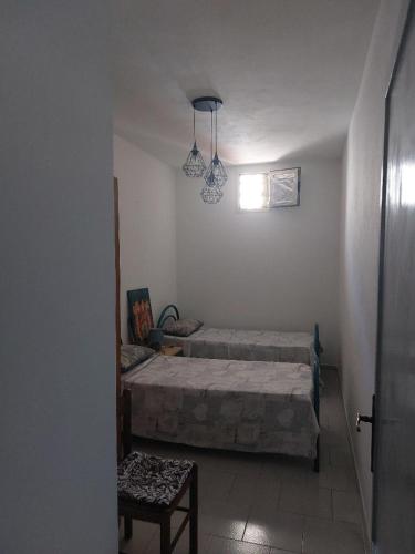 a bedroom with two beds and a table and a window at Casa Samuel in Galtellì