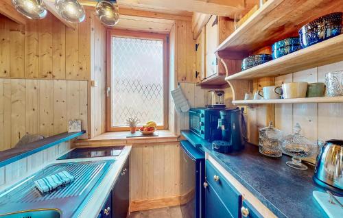 - une cuisine avec des murs en bois et un comptoir bleu dans l'établissement Lovely Home In Gérardmer With Wifi, à Gérardmer