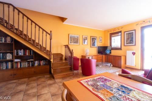 a living room with a staircase and a book shelf at La Casetta - panoramic view in Fiumelatte