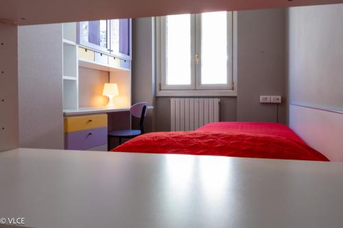 a bedroom with a red bed and a desk at La Casetta - panoramic view in Fiumelatte