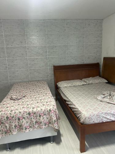 two beds sitting next to each other in a room at Suíte com entrada independente Pelotas in Pelotas