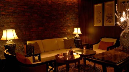 a living room with a couch and chairs and tables at The Naha Terrace in Naha