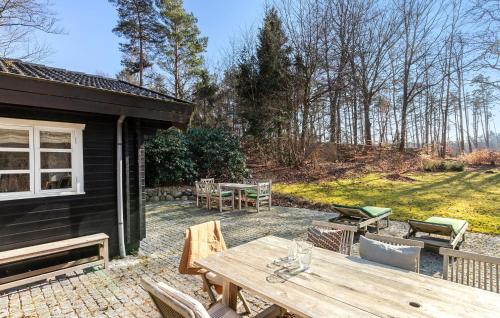 a patio with a table and chairs and a building at Lovely Home In Tisvildeleje With Sauna in Tisvildeleje