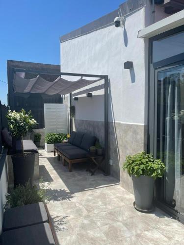 a patio with a couch under a canopy at City Sea House in Villaggio San Leonardo