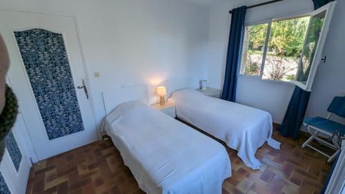 deux lits dans une chambre avec une fenêtre dans l'établissement superb Provençal house, à Vence