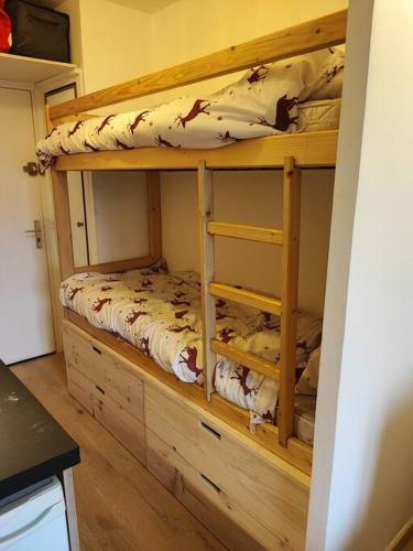 un lit superposé en bois dans une pièce avec cuisine dans l'établissement Charmant Studio -La Foux d'Allos, à Allos