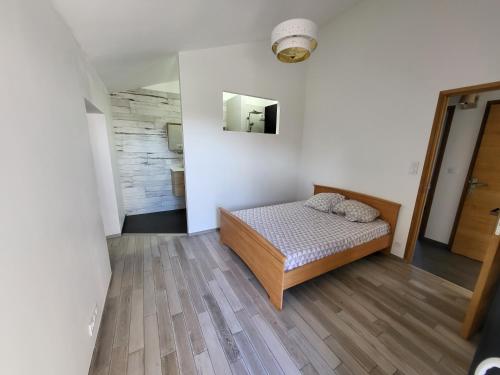 une chambre avec un lit et un miroir au mur dans l'établissement La cave de la Sangueze, à Mouzillon