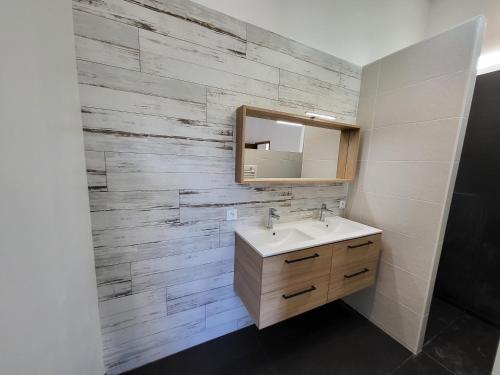 une salle de bain avec un lavabo et un miroir dans l'établissement La cave de la Sangueze, à Mouzillon