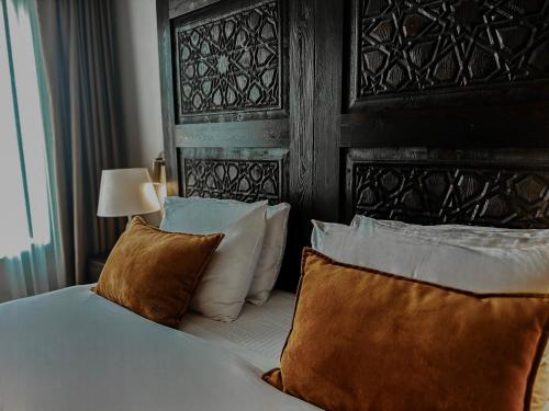 a bedroom with a bed with a wooden headboard and pillows at Osmanli Cappadocia Hotel in Goreme