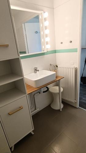une salle de bain avec un lavabo et un miroir et des toilettes dans l'établissement Studio cosy pour curistes avec terrasse, vue sur piscine, à Balaruc-les-Bains