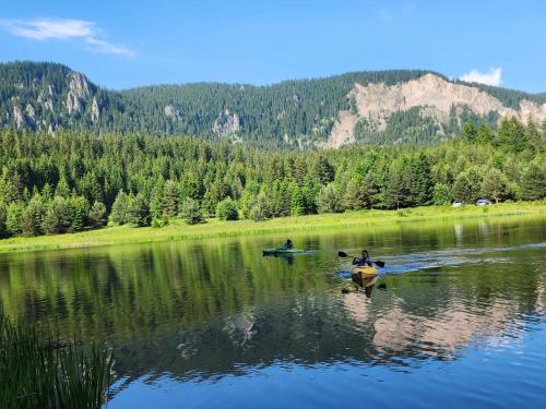 two people in kayaks on a lake in the mountains at SPA Hotel Daffi in Smolyan