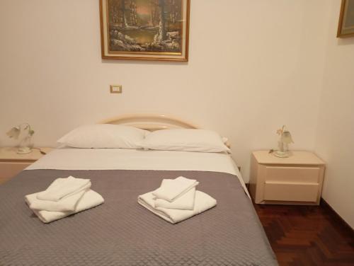 a bedroom with a bed with white towels on it at Bed and Breakfast Verdoni di Gabriela in Rome