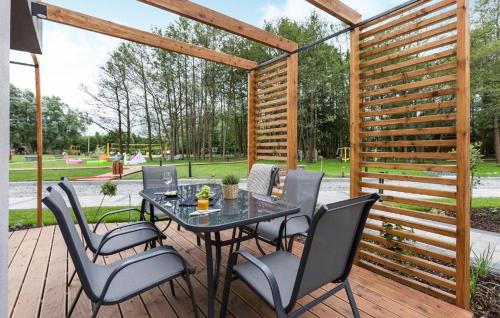 a patio with a table and chairs on a wooden deck at Awesome Apartment In Niechorze in Niechorze