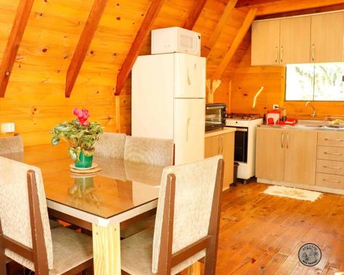 a kitchen with a dining room table with a refrigerator at Recanto dos Xaxins in São Francisco de Paula