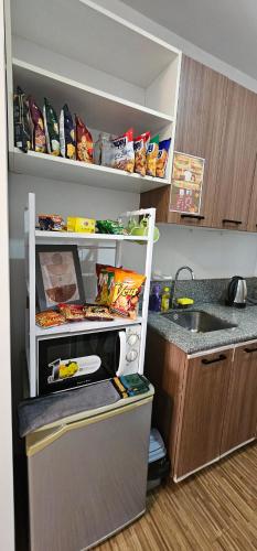 a small kitchen with a sink and a microwave at Laidback Cavern at Studio City Alabang in Manila