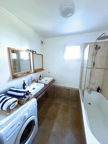a bathroom with a washing machine and a bath tub at uta house la plaine in Saint-Denis