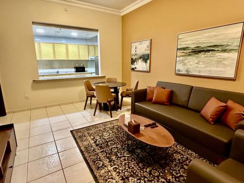 a living room with a couch and a table at Al Nakheel Hotel Apartments Abu Dhabi in Abu Dhabi