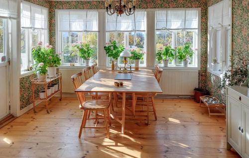 a dining room with a table and chairs and windows at Nice Home In Ljusterö With Sauna in Norra Ljustero
